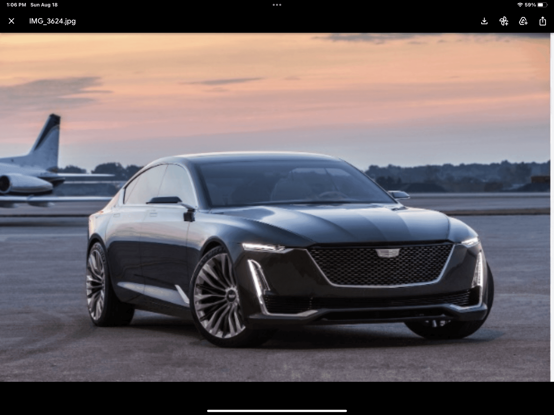 Luxury black sedan parked on an airstrip at sunset, with a private jet in the background.